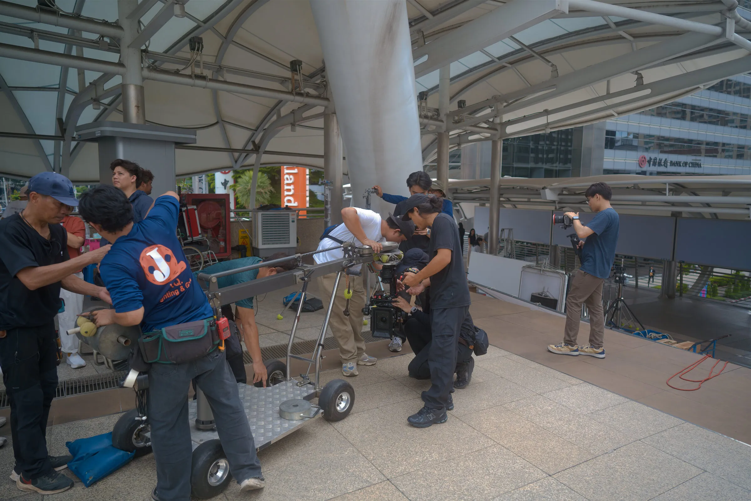 Grips setting up a dolly with the camera team on a covered walkway location