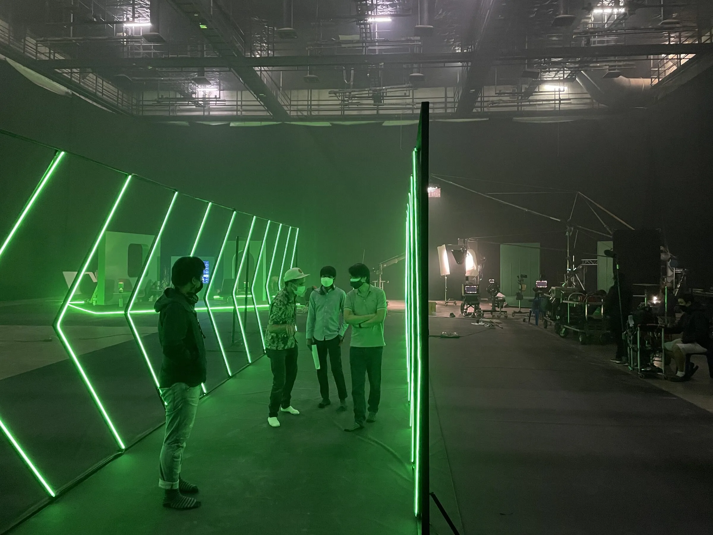 Crew walking through the green neon set built for the FBS commercials
