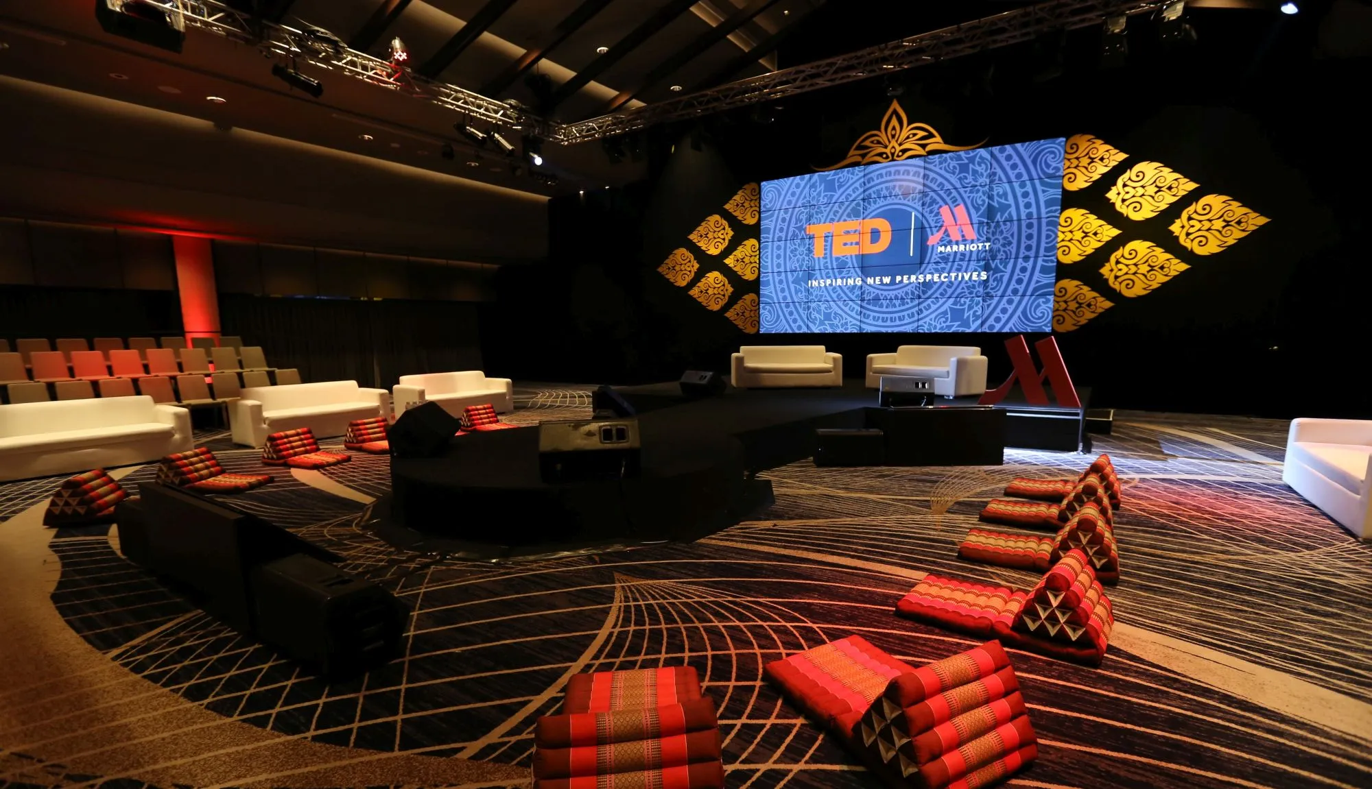 Event venue with a TED stage and red lounge seating in Bangkok