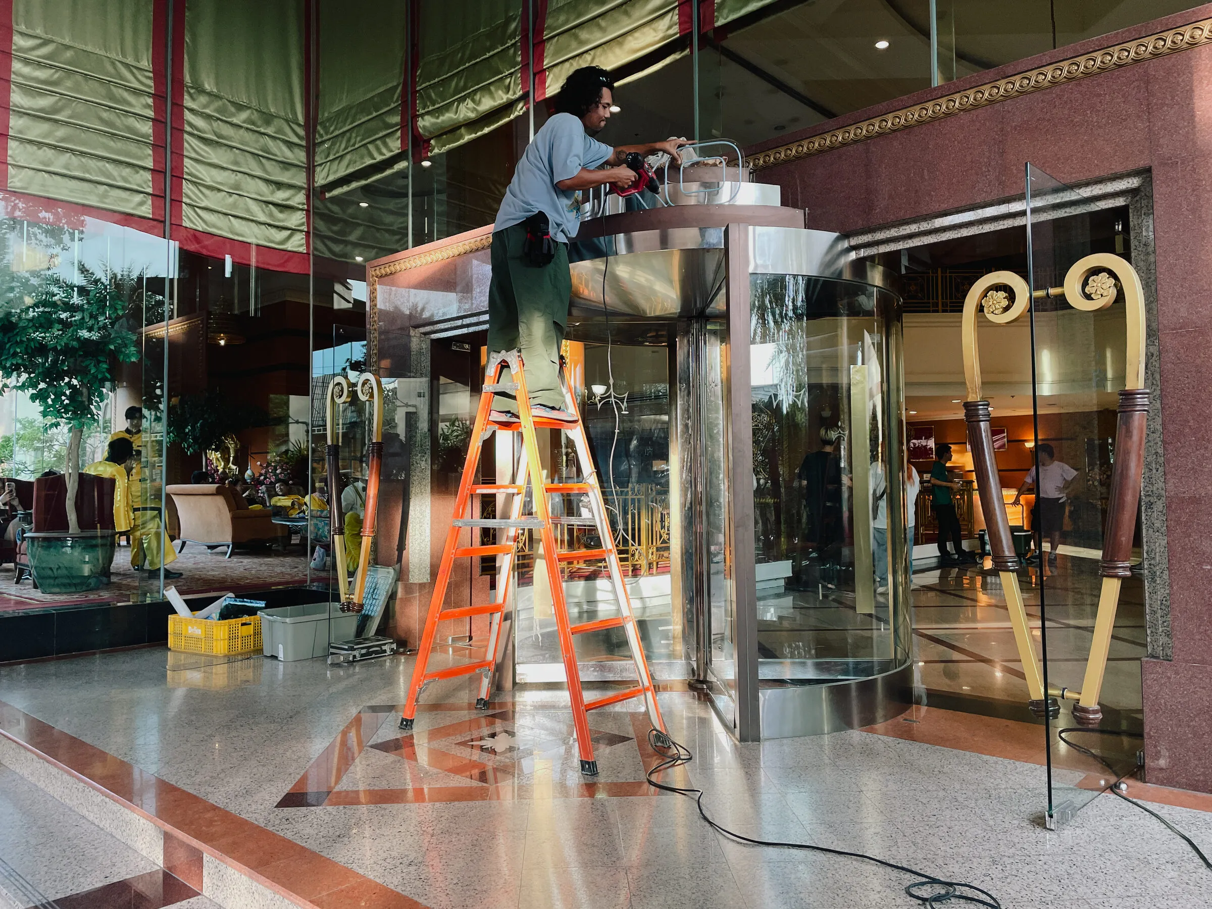 KOKO music video: art crew on a ladder dressing the hotel entrance
