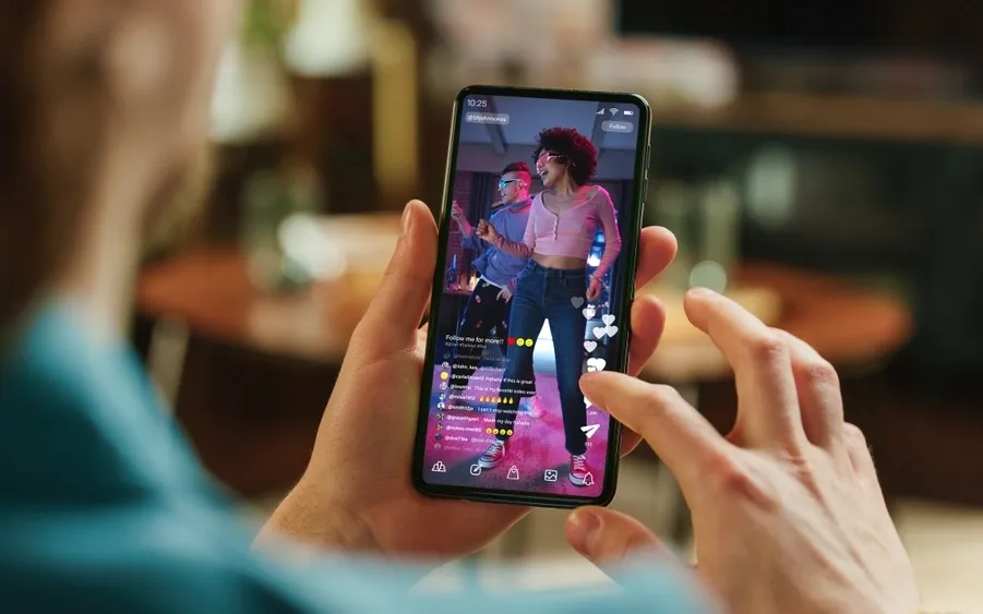 Hands holding a phone playing a dance video