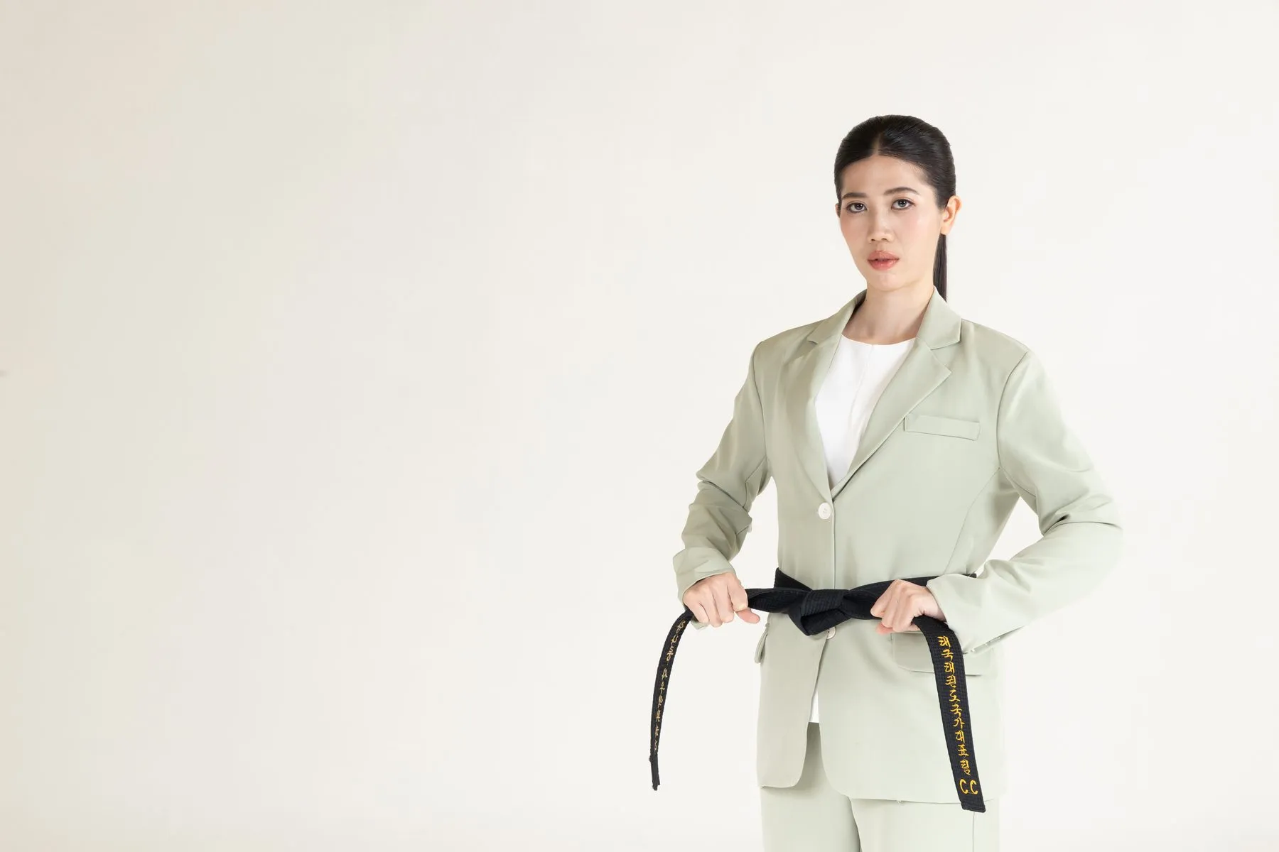 Tennis in a sage suit holding her black belt